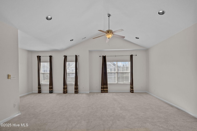 unfurnished room with ceiling fan, vaulted ceiling, plenty of natural light, and light carpet