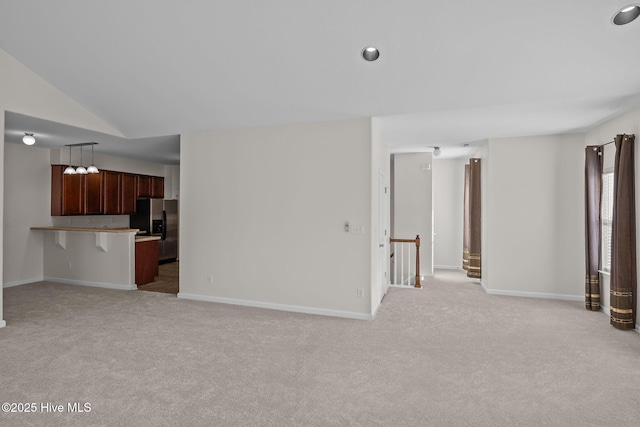 unfurnished living room featuring lofted ceiling and light colored carpet