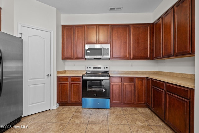 kitchen with light tile patterned floors and stainless steel appliances