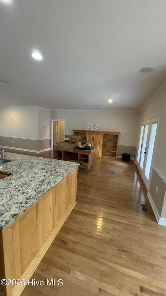 kitchen featuring light hardwood / wood-style floors, light stone countertops, light brown cabinets, and french doors