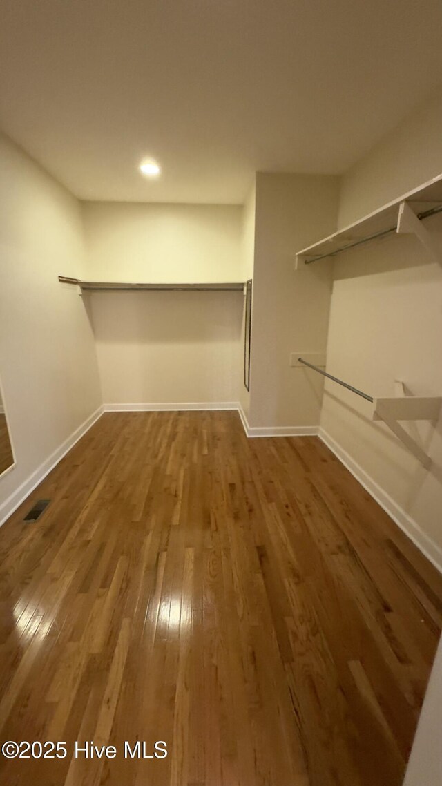 corridor with hardwood / wood-style flooring