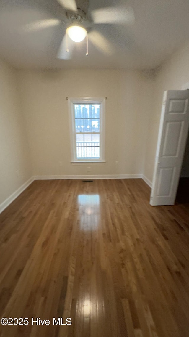 empty room featuring ceiling fan and dark hardwood / wood-style floors