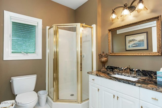 bathroom with toilet, vanity, and a shower with door