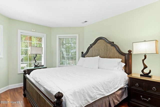 bedroom featuring dark wood-type flooring and multiple windows