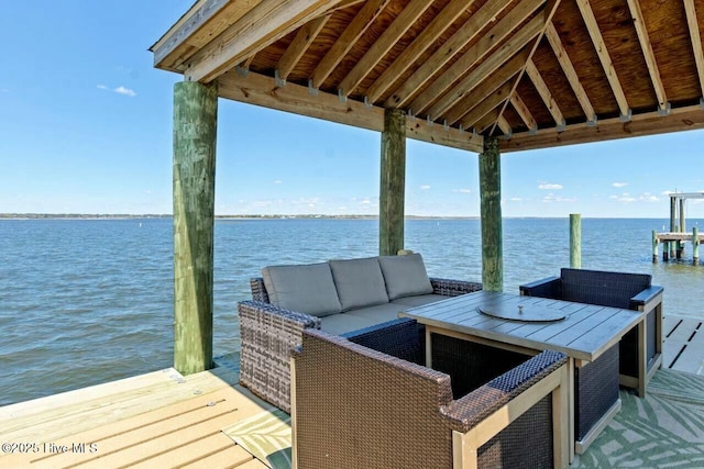 view of dock with outdoor lounge area, a gazebo, and a water view