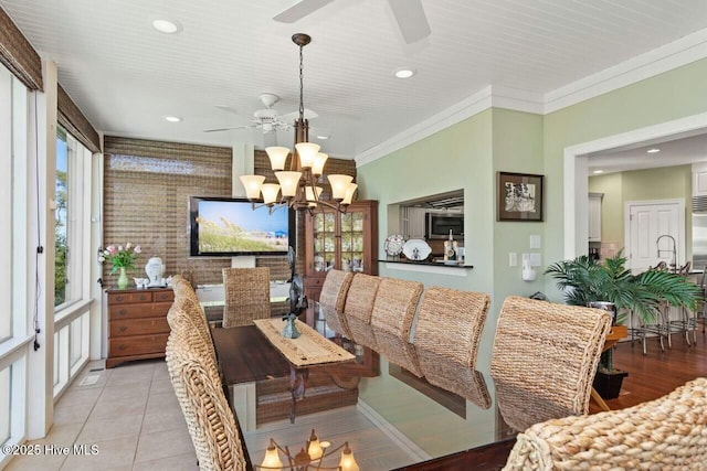 tiled dining room featuring ceiling fan with notable chandelier, a wealth of natural light, and crown molding