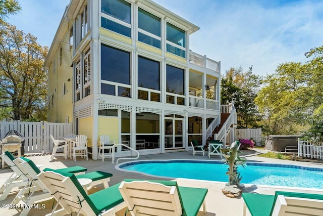 rear view of house featuring ceiling fan, a pool with hot tub, and a patio