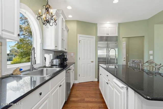 kitchen featuring sink, white cabinetry, a wealth of natural light, and a notable chandelier