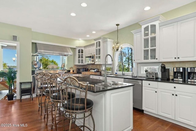 kitchen featuring white cabinets, hanging light fixtures, stainless steel dishwasher, and a center island