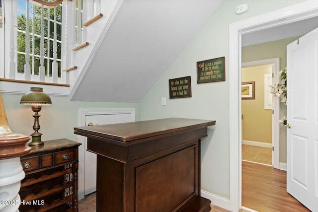 office area with light wood-type flooring and vaulted ceiling