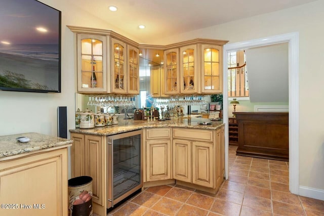 kitchen featuring wine cooler, plenty of natural light, and light stone counters