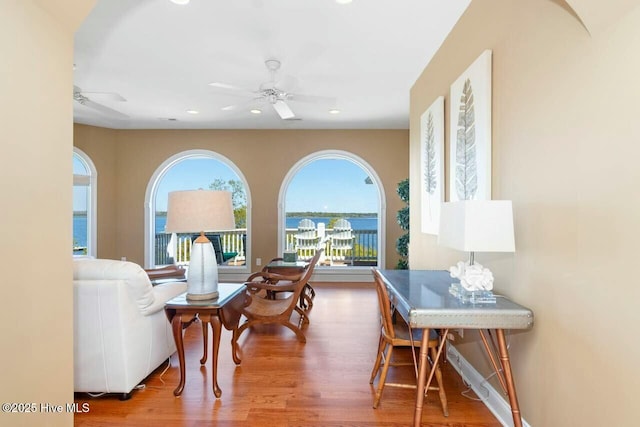 living room with ceiling fan, hardwood / wood-style floors, and a water view