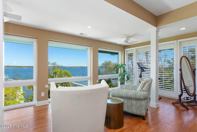 interior space featuring ceiling fan, plenty of natural light, and a water view