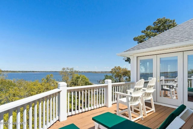 deck with a water view and french doors