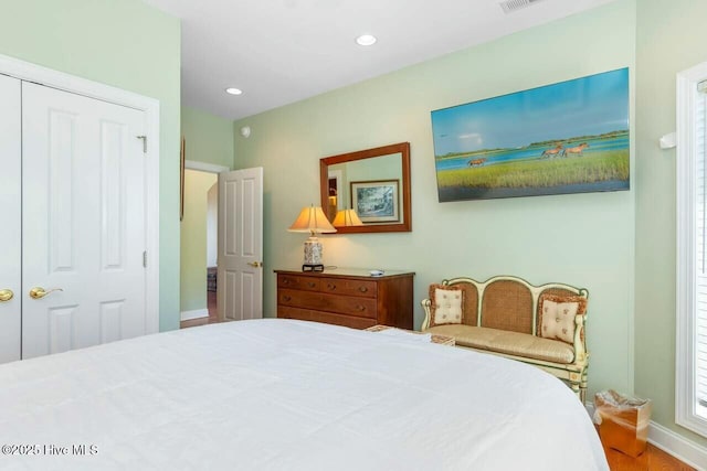 bedroom with wood-type flooring and a closet