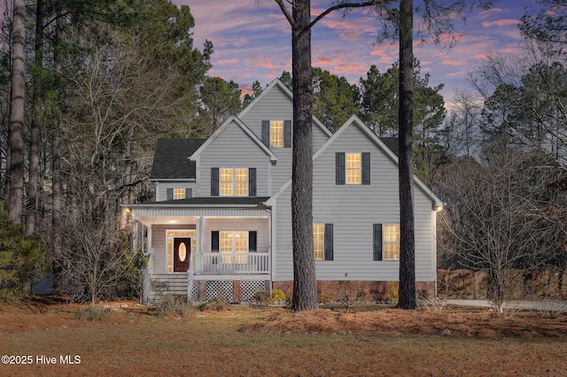 view of front of home with covered porch and a lawn