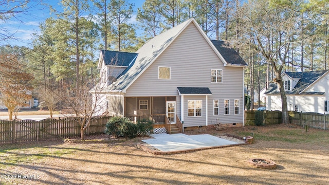 rear view of property with a yard, a patio area, and a sunroom