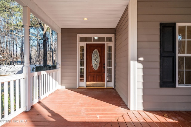 view of exterior entry featuring covered porch