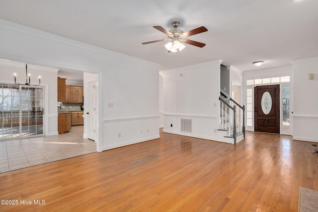 unfurnished living room with ornamental molding, light hardwood / wood-style floors, and ceiling fan