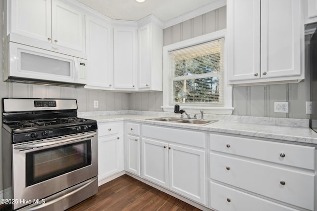 kitchen featuring light stone countertops, white cabinetry, sink, and stainless steel gas range oven