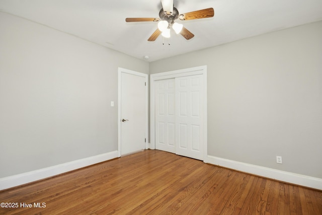 unfurnished bedroom featuring ceiling fan, hardwood / wood-style flooring, and a closet