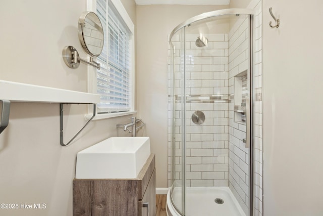 bathroom with a shower with door and vanity