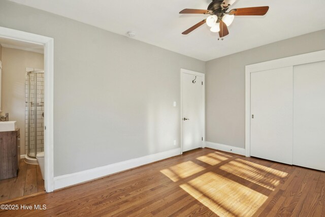 unfurnished bedroom with ceiling fan, wood-type flooring, and a closet