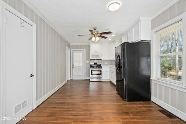 kitchen featuring a healthy amount of sunlight, black refrigerator with ice dispenser, stainless steel range oven, and white cabinetry