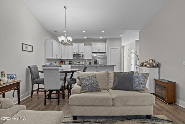 living room featuring a notable chandelier and dark hardwood / wood-style floors