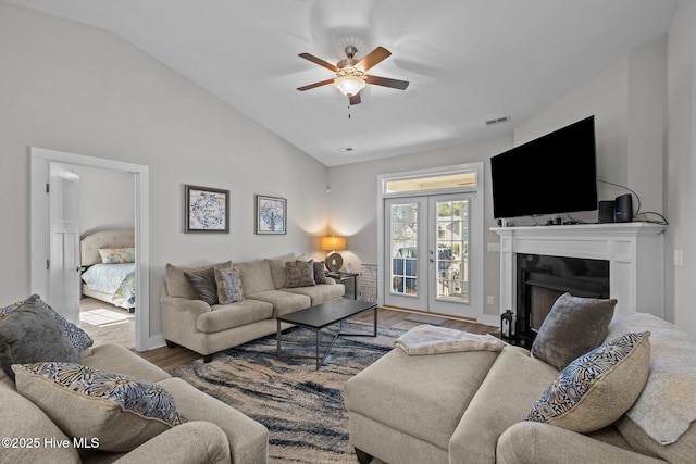 living room featuring ceiling fan, hardwood / wood-style floors, lofted ceiling, and french doors