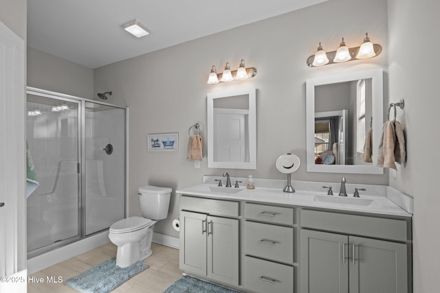 bathroom featuring a shower with door, toilet, and vanity