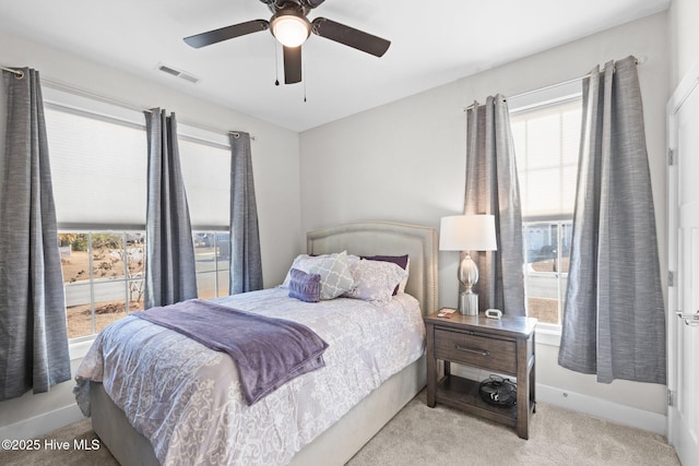 carpeted bedroom featuring ceiling fan and multiple windows