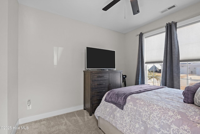 carpeted bedroom featuring ceiling fan and multiple windows