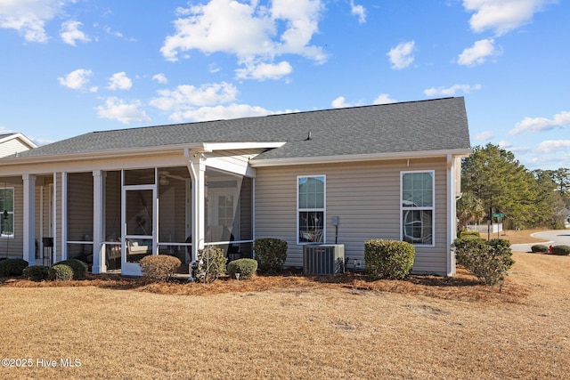 rear view of property with a sunroom, a lawn, and cooling unit