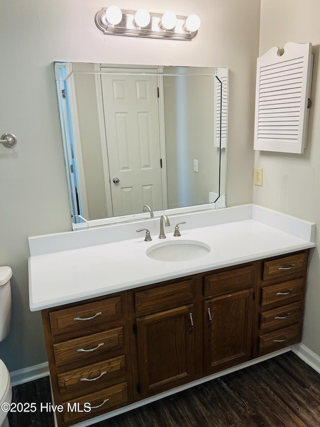 bathroom featuring vanity, hardwood / wood-style flooring, and toilet