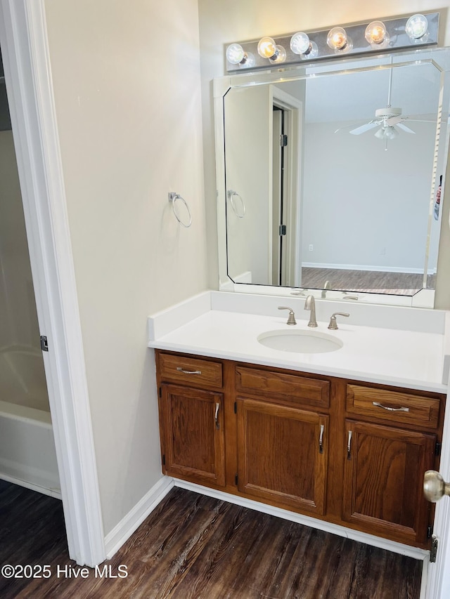 bathroom featuring vanity, a tub to relax in, wood-type flooring, and ceiling fan