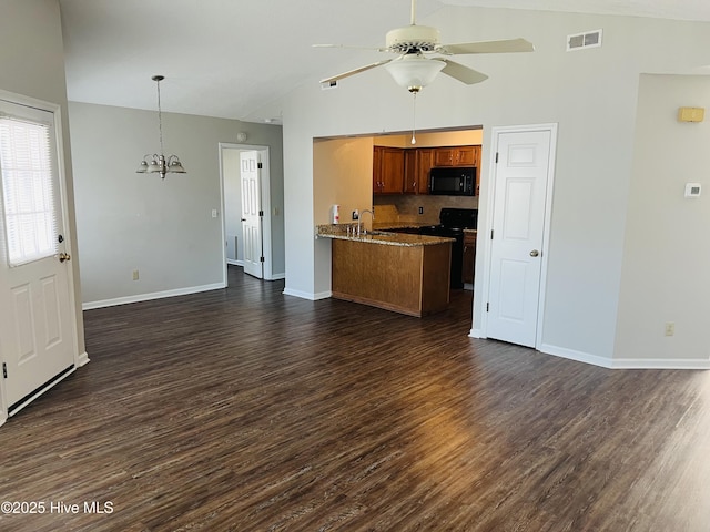 kitchen with lofted ceiling, dark hardwood / wood-style floors, black appliances, and kitchen peninsula