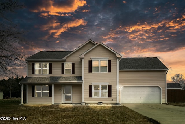 view of front of property featuring a garage and a lawn