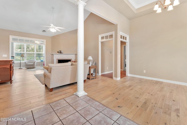 living room featuring decorative columns, ceiling fan with notable chandelier, ornamental molding, and light hardwood / wood-style floors