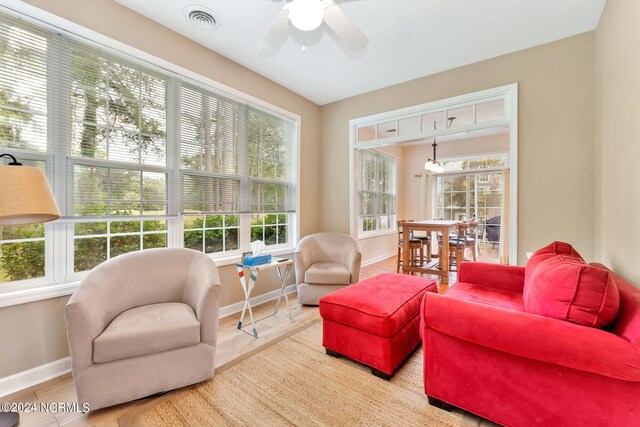 sunroom / solarium featuring a wealth of natural light and ceiling fan with notable chandelier