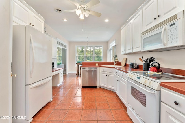 kitchen featuring ceiling fan with notable chandelier, pendant lighting, white appliances, white cabinetry, and light tile patterned floors