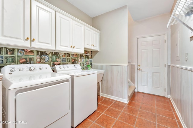 washroom with cabinets, light tile patterned floors, and washing machine and clothes dryer