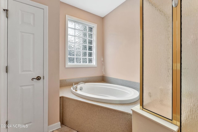 bathroom with a relaxing tiled tub