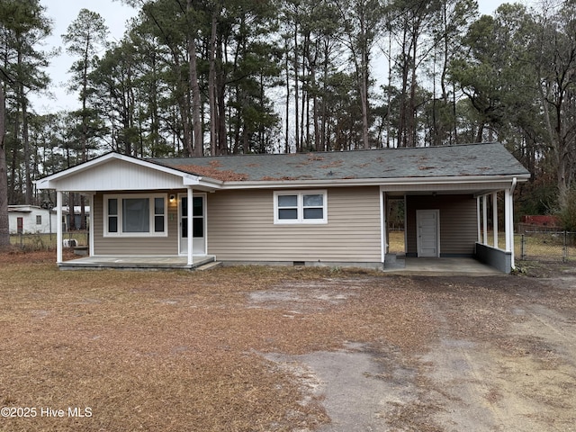 ranch-style house featuring a carport and covered porch