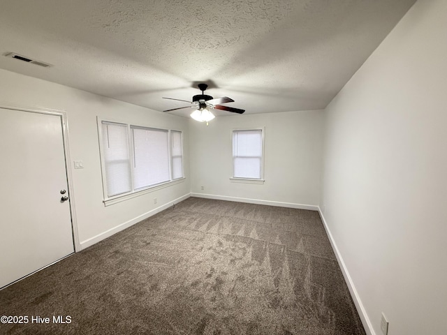 carpeted spare room with ceiling fan and a textured ceiling