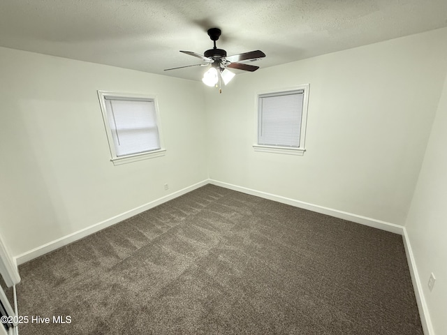 carpeted spare room featuring ceiling fan and a textured ceiling