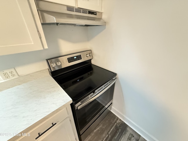 kitchen with hardwood / wood-style flooring, electric stove, and white cabinets