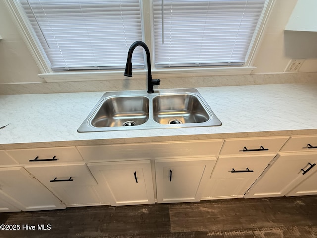 kitchen with dark wood-type flooring, sink, and white cabinetry