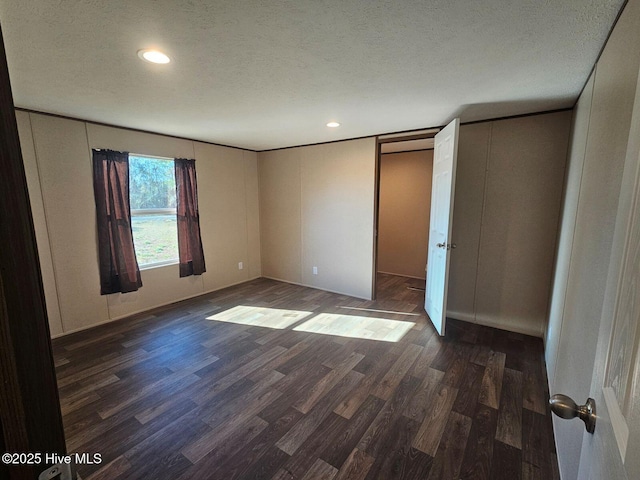 unfurnished bedroom featuring dark wood-type flooring and a textured ceiling