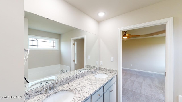 bathroom with ceiling fan, vanity, and a bathtub